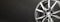 new grey alloy wheels on a dark textured black background. car wheel , copy space panorama empty space