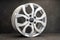 new grey alloy wheels on a dark textured black background. a wheel for a car