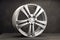 new grey alloy wheels on a dark textured black background. a wheel for a car