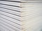 New gypsum plasterboard sheets stacked in pairs