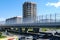 New high-rise buildings. The lower side of the elevated road. Viaduct on the motorway. Summer background. Highway-road