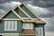 New Home House Exterior Green Siding Roof Peaks Clouds