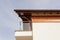 New house with brown rain gutter, white wall and balcony.