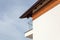 New house with brown rain gutter, white wall and balcony.