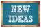 NEW IDEAS words on blue wooden frame school blackboard