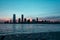 New Jersey cityscape at sunrise with skyscrapers silhouettes and a sea reflecting colors