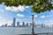 New Jersey skyline from Battery Park in a sunny day. Cityscape view through trees and streetlamp. City and travel concept.