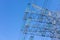 New large mast of an air power line close up, high voltage electricity pylon with thick wires and insulators, blue sky