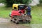 New large petrol water pump next to small electrical water pump and thick red hose all put on wooden pallets waiting to be used