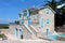 New Mediterranean villa built with stone in traditional style with blue wooden window blinds and doors next to swimming pool