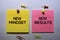 New Mindset - New Results text on sticky notes isolated on office desk