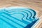 New modern fiberglass plastic swimming pool entrance step with clean fresh refreshing blue water on bright hot summer