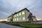 New modern two-storied kindergarten preschool building,green grassy lawn and paved sidewalks on blue sky copy space background.