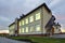 New modern two-storied kindergarten preschool building,green grassy lawn and paved sidewalks on blue sky copy space background.