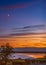 A new moon above Sandwich Bay as the golden sunset reflects into the low tide of the bay