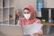 New normal of Asian business Muslim or islam women wearing face protective mask in casual working with laptop and smile
