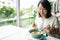 New normal Middle-aged Asian woman Eating food with a plastic plate to prevent the spread of the virus. Social distancing and and