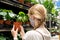 New normal retail shopping. A girl wearing face mask choosing potted plants in retail garden warehouse store shop. Covid-19