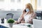 New normal and return to workplace after quarantine.Young attractive woman in a protective mask talks on smartphone and