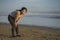 New normal running workout of Asian girl in face mask - young happy and beautiful Korean woman jogging on the beach in post