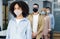 New normal and temperature check before work. Millennial multiracial employees in protective masks stand in line with