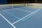 New outdoor blue tennis court with white lines combined with light blue pickleball lines