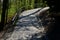 A new park path made of irregular cubes, folded with a side channel for draining water from the road surface. granite stones of gr