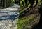 A new park path made of irregular cubes, folded with a side channel for draining water from the road surface. granite stones of gr