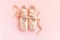 New pastel beige ballet shoes with satin ribbon isolated on pink background. Ballerina classical pointe shoes for dance training.
