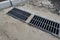 New rainwater grate on the road or sidewalk, installation in concrete. City sewage system for draining water during heavy rain