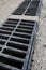 New rainwater grate on the road or sidewalk, installation in concrete. City sewage system for draining water during heavy rain