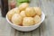 New Raw Potatoes in Bowl on Rustic Wooden table. Close up view, Wooden Spoons, over Wooden Background.