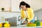 New recipe, food blog. Happy young african american lady cutting vegetables in kitchen interior, using laptop