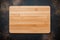 New rectangular bamboo wooden cutting board on stone background. Top view. Mock up for food project