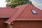 New Red Shingles Roof with Skylights Windows and Rain Gutter. New brick house with chimney