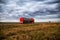 New red truck with a tanker truck transports gasoline against the background of the cloudy sky in the evening. Dangerous goods