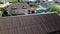 New roof covering on background of village. Stock footage. Top view of ridge of new roof on background of village houses