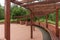 New round wooden pergola with long bench