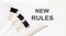 NEW RULES written on a white page with office tools