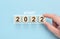 New start 2022 concept. Loading new year 2022 with hand putting wood cube in progress bar. Happy new year 2022. Start concept