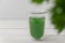 New superfood trend liquid chlorophyll in a cup with water on light background