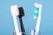 A new toothbrush and an old damaged toothbrush in a glass from a transparent glass for brushing your teeth, the concept