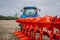 New tractor with red plow in motion at demonstration field site at agro exhibition AgroExpo. Tractor working on the farm, modern