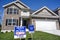 New two-story, brick facade home built by McBride Construction Company for sale sign in yard