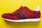 New unbranded running sneaker or trainer on yellow background. Men`s sport footwear