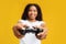 New videogame advertisement concept. Overjoyed african american woman holding game controller, yellow background