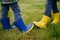 New way of greeting. Two people bump their rubber boots demonstrating a new way of greeting, instead of hugs or handshaking