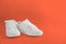 New white female or teen sneakers isolated on coral background. White textile sneakers with rubber soles with tied laces on a