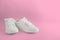 New white female or teen sneakers isolated on pink background. White textile sneakers with rubber soles with tied laces on a