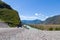 A new winding asphalt black road with a yellow dividing strip between the rocks and the Katun River in the Altai mountains under a